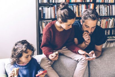 πατέρας και παιδιά παίζουν με τα κινητά τους